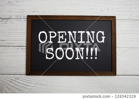Opening Soon!!! text with blackboard on white brick background 128342329