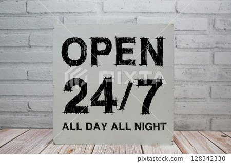 Open 24/7 All Day All Night sign with blackboard on white brick background 128342330