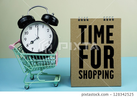 Time For Shopping wiht mini trolley shopping cart and alarm clock on blue and yellow background 128342525