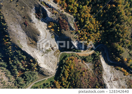 Aerial top down view of deep canyon, gorge road in autumn forest 128342640
