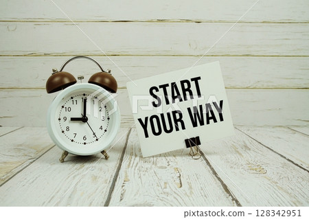Start Your Way text on paper card with alarm clock on wooden background 128342951
