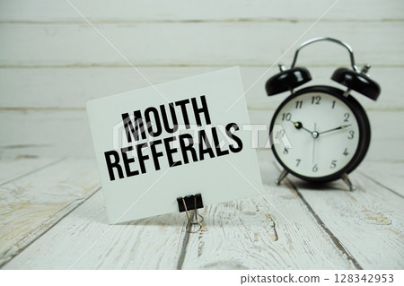 Mouth Refferals text on paper card with alarm clock on wooden background 128342953