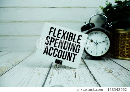 Flexible Spending Account text on paper card with alarm clock on wooden background 128342962