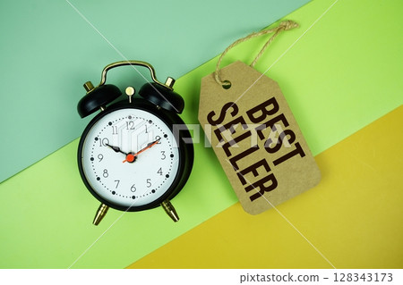 Best Seller text on price tag with alarm clock on yellow background 128343173