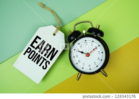 Earn Points text on price tag with alarm clock on yellow background Earn Points text on price tag with alarm clock on yellow background 128343176