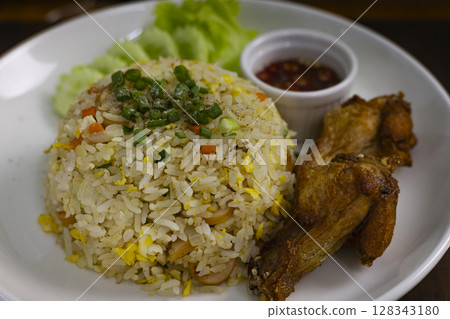 Fried Rice With Egg And Fried Chicken On Plate, Background for advertising and wallpaper in culture and food scene. Fried Rice With Egg And Fried Chicken On Plate, Background for advertising and wallpaper in culture and food scene. 128343180