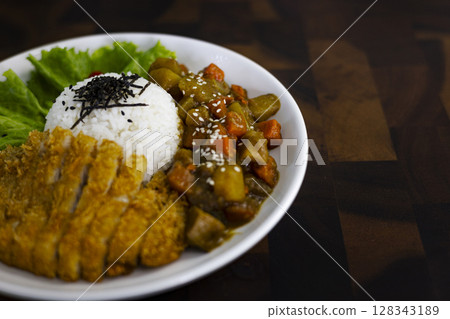 Fried Chicken Curry Rice On A Plate Placed On A Wooden Table, Background for advertising and wallpaper in culture and food scene. Fried Chicken Curry Rice On A Plate Placed On A Wooden Table, Background for advertising and wallpaper in culture and food scene. 128343189