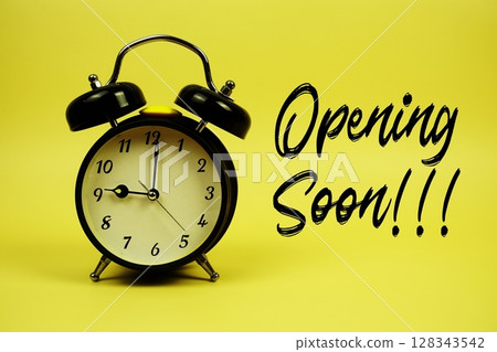 Opening Soon text with alarm clock on yellow background Opening Soon text with alarm clock on yellow background 128343542