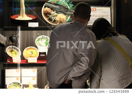 Customers looking at udon samples 128343899