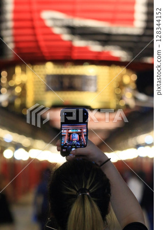 Foreign tourists taking photos of the giant lantern at Kaminarimon Gate at night Foreign tourists taking photos of the giant lantern at Kaminarimon Gate at night 128344152