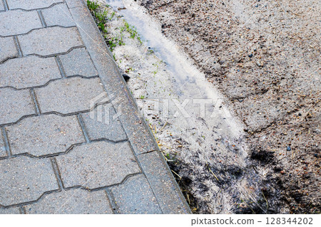 This is a close up view of a brick sidewalk with water flowing out of it 128344202