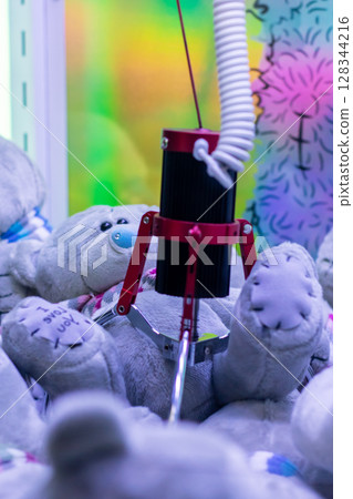 A group of beloved teddy bears is being clawed at by a machine 128344216