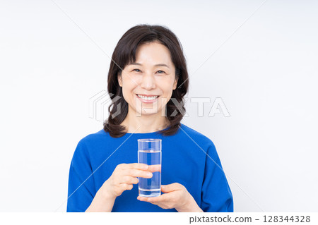 Middle aged woman drinking mineral water Middle aged woman drinking mineral water 128344328