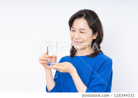 Middle aged woman drinking mineral water Middle aged woman drinking mineral water 128344331