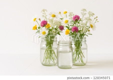 Bouquets of wildflowers in jars of water. 128345071