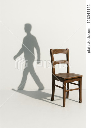 An empty chair casts the shadow of a walking person. An empty chair casts the shadow of a walking person. 128345131