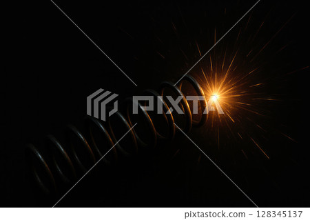 A metal spiral with a bright flash of light. A metal spiral with a bright flash of light. 128345137
