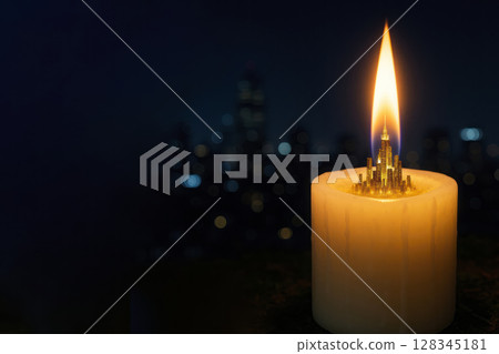 A huge city burning in the flame of a candle at night. Space for text. A huge city burning in the flame of a candle at night. Space for text. 128345181