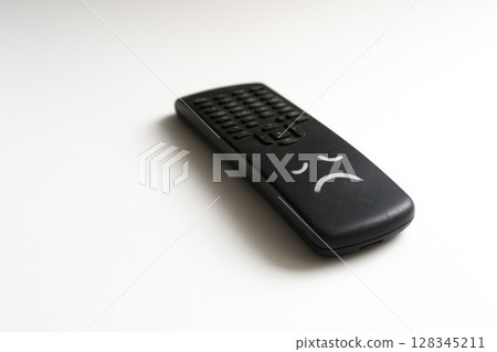 A remote control with a painted sad face. Space for text. 128345211