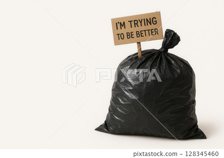 A bag of garbage with a sign saying I'm trying to be better. Space for text. 128345460
