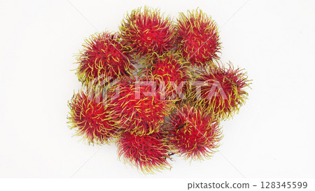 Overhead shot of multiple ripe rambutan fruits with vivid red skin and soft yellow-green spines, arranged on a clean white background. Perfect for food advertisements Overhead shot of multiple ripe rambutan fruits with vivid red skin and soft yellow-green spines, arranged on a clean white background. Perfect for food advertisements 128345599