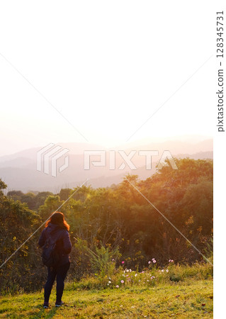Asian young woman backpack smiling and standing with wildflower and beautiful landscape of valley Doi Luang Chiang Dao mountain, Chiang Mai Province of Thailand 128345731