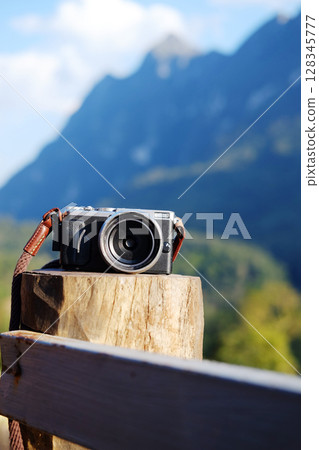 Vintage mirrorless camera on wooden pole of terrace with valley Doi Luang Chiang Dao mountain view, Chiang Mai Province of Thailand Vintage mirrorless camera on wooden pole of terrace with valley Doi Luang Chiang Dao mountain view, Chiang Mai Province of Thailand 128345777