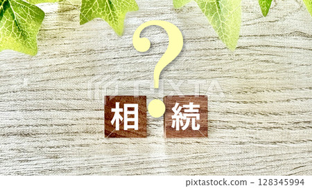 Wooden cube with inheritance letters and question marks_whiteboard background 128345994