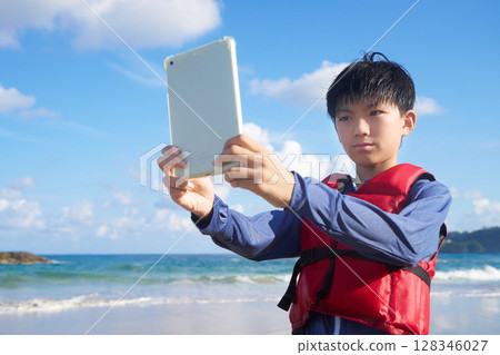 夏日海灘上玩平板電腦的小學生 128346027