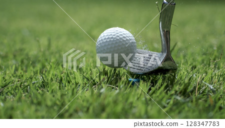 Golf club hits a golf ball. 128347783