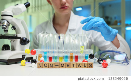 A scientist conducts nonmetal experiments in a lab, emphasizing research techniques and safety A scientist conducts nonmetal experiments in a lab, emphasizing research techniques and safety 128349036