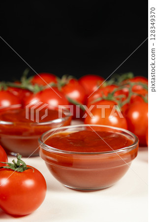 Glass Bowls of Ketchup Surrounded by Fresh Tomatoes. Homemade Sauce Concept. Glass Bowls of Ketchup Surrounded by Fresh Tomatoes. Homemade Sauce Concept. 128349370