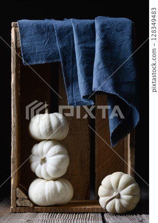 White decorative Baby Boo pumpkins in wooden box with blue napkin White decorative Baby Boo pumpkins in wooden box with blue napkin 128349483