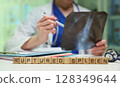 The doctor is carefully reviewing the Xray images to confirm a diagnosis of a ruptured spleen 128349644