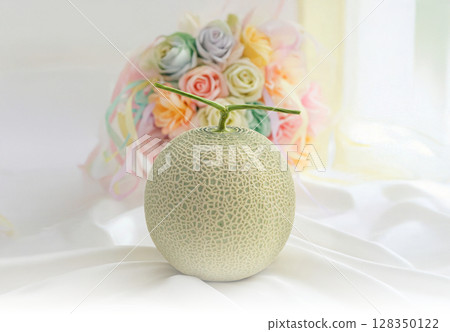 Symbolically placed on the table is a muskmelon and a bouquet of flowers. Gifts, product photography, midyear gifts, year-end gifts, high-quality melons 128350122