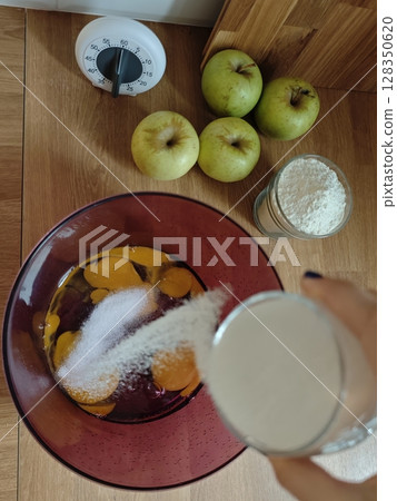 Sweet moments come alive as sugar blends with fresh eggs to create a delightful batter under warm kitchen lights Sweet moments come alive as sugar blends with fresh eggs to create a delightful batter under warm kitchen lights 128350620