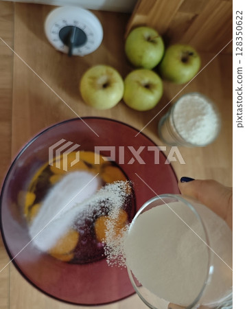 Mixing fresh ingredients for a delicious apple dessert in a cozy kitchen Mixing fresh ingredients for a delicious apple dessert in a cozy kitchen 128350622