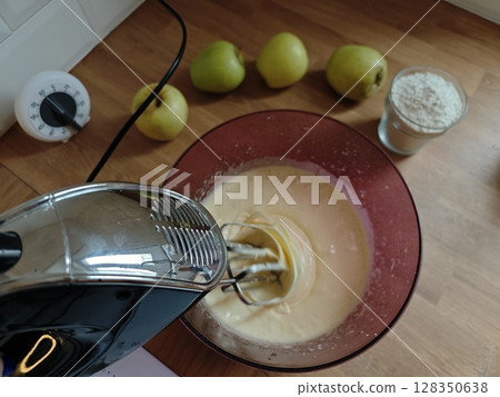 Mixing batter for a delicious pear cake in a cozy kitchen setting with fresh ingredients and a bright atmosphere Mixing batter for a delicious pear cake in a cozy kitchen setting with fresh ingredients and a bright atmosphere 128350638