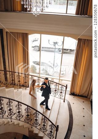 The bride and groom are on a beautiful staircase. 128350678