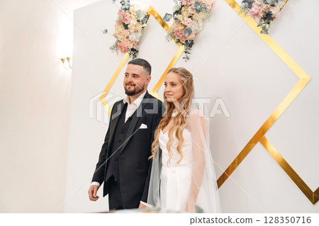 The bride and groom at the ceremony in the Wedding Palace. The bride and groom at the ceremony in the Wedding Palace. 128350716