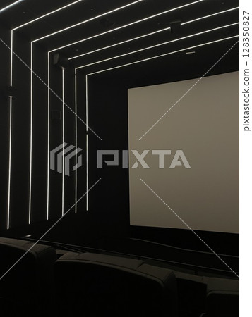 Modern empty cinema hall with LED ceiling lights and blank screen. Minimalist interior design of movie theater with comfortable seats. Vertical photo, futuristic style. 128350827