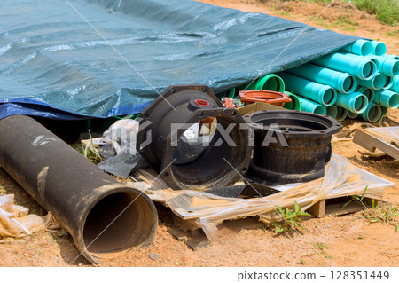 Collection of plumbing materials like pipes fittings is displayed at construction site under works day Collection of plumbing materials like pipes fittings is displayed at construction site under works day 128351449