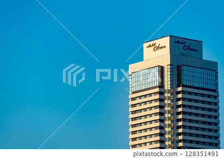 Skyscraper that shines in the blue sky Skyscraper that shines in the blue sky 128351491