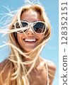 Close-up portrait of a happy smiling blonde woman in sunglasses on a sunny day. 128352151