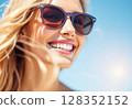 Close-up portrait of a happy smiling blonde woman in sunglasses on a sunny day. 128352152