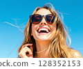 Close-up portrait of a happy smiling blonde woman in sunglasses on a sunny day. 128352153