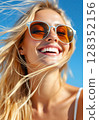 Close-up portrait of a happy smiling blonde woman in sunglasses on a sunny day. 128352156