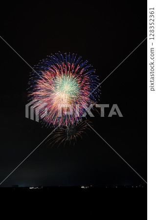 Large fireworks blooming in the summer night sky 128352361