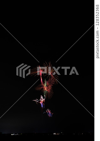 Large fireworks blooming in the summer night sky 128352368