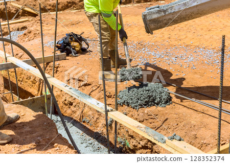 Workers perform concrete pouring at construction site on building new homes under works day Workers perform concrete pouring at construction site on building new homes under works day 128352374